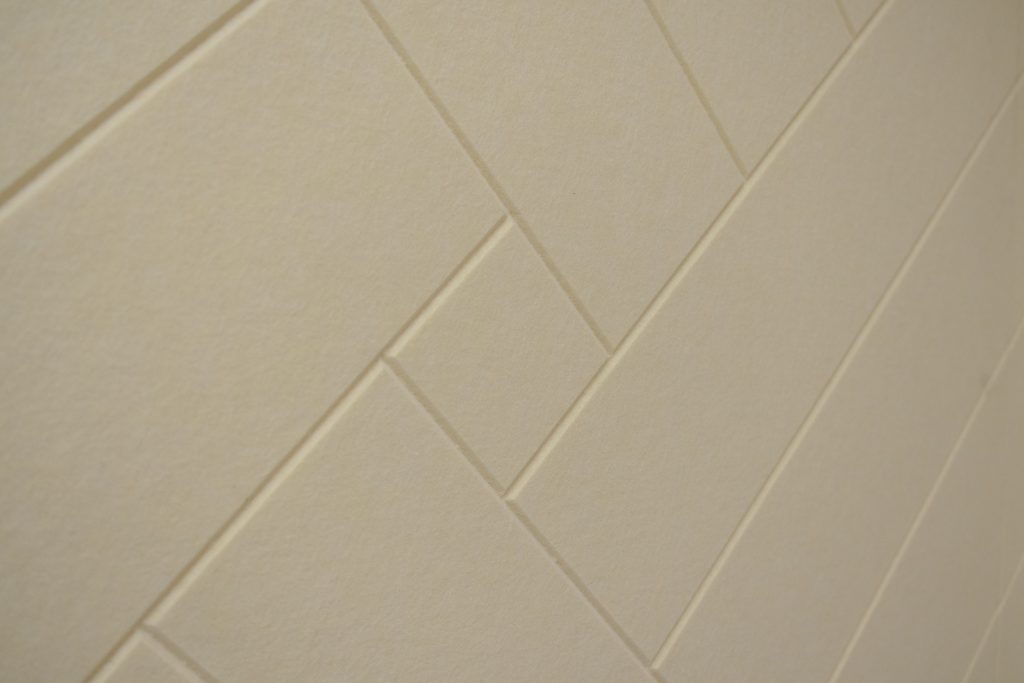 Acoustic panel wall with groove pattern reducing sound reflections in consultation space