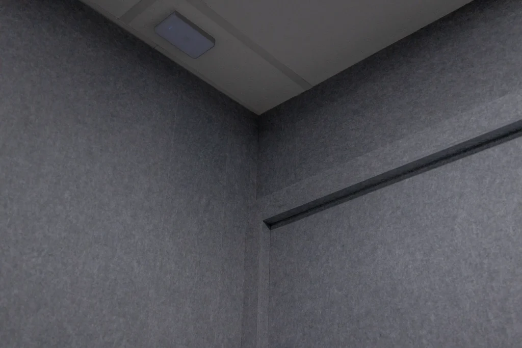 Ceiling corner junction of Klar™ Essentials acoustic panels with black trim strip at Weave office Singapore