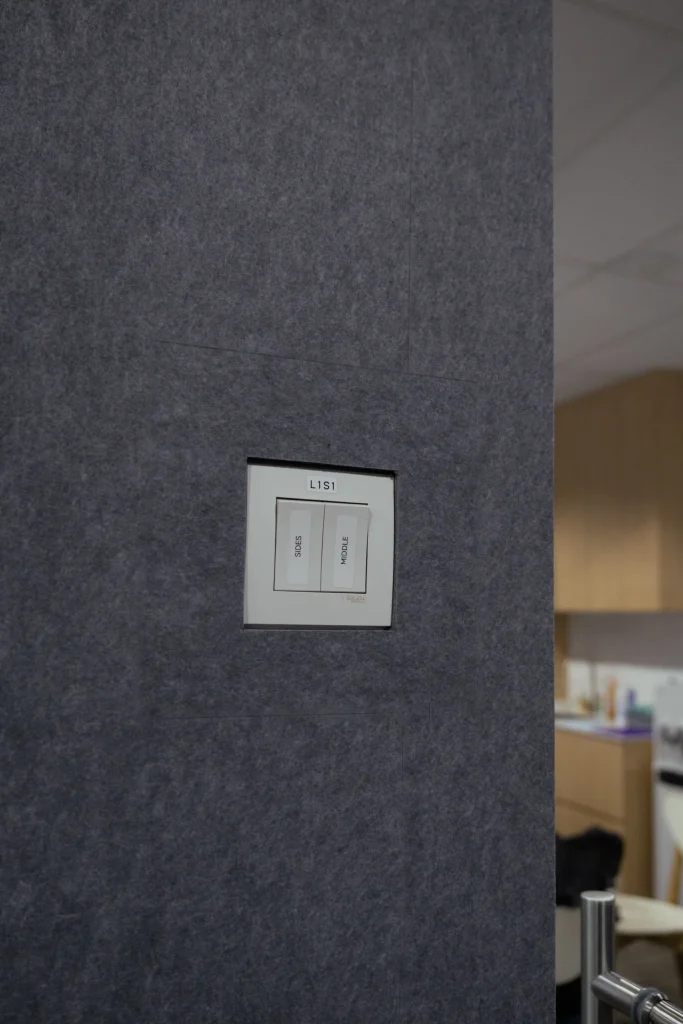 Light switch panel flush-cut into Klar™ Essentials CM19 Moonlight acoustic wall panels at Weave office Singapore