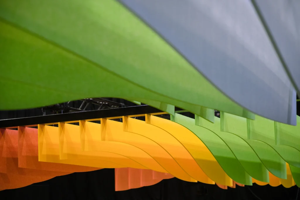 Close-up of curved Klar™ ceiling baffles in orange, yellow and green felt at the Obayashi Theatre, BEX Asia 2025