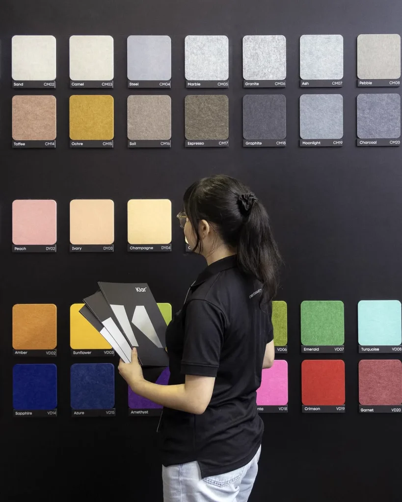 Visitor browsing the Klar™ Essentials acoustic panel colour wall at the Klar booth, BEX Asia 2025